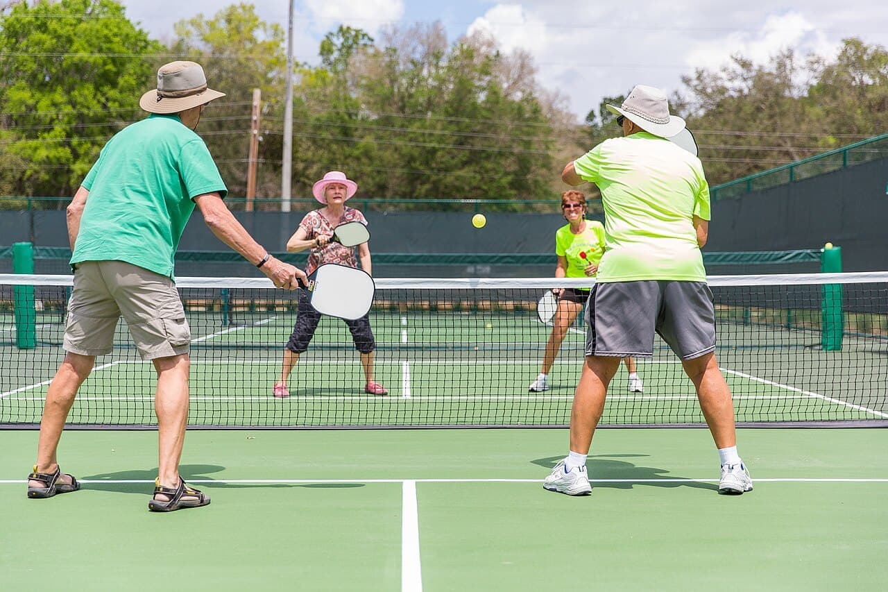 A group of adults playing pickleball on outdoor courts at The Villages, Florida.