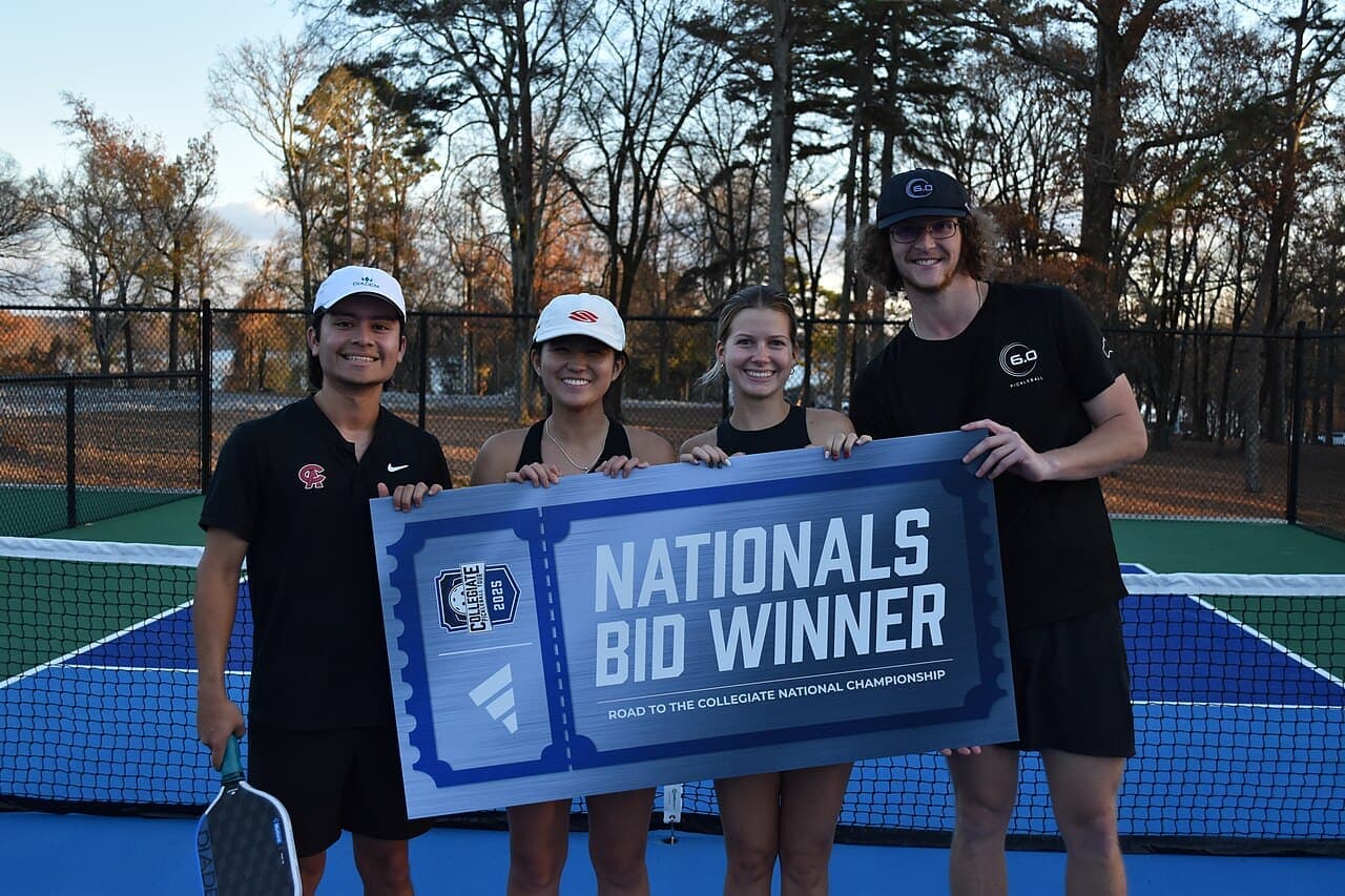 Four University of Alabama in Huntsville pickleball players standing on a court with paddles.